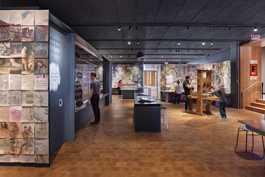 An exhibit hall at the Folger featuring various displays and interactive elementsri, with visitors exploring and engaging with the exhibits.