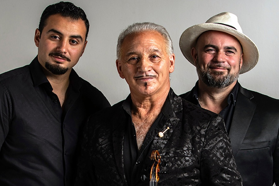 A trio of musicians posing together, ready to perform.