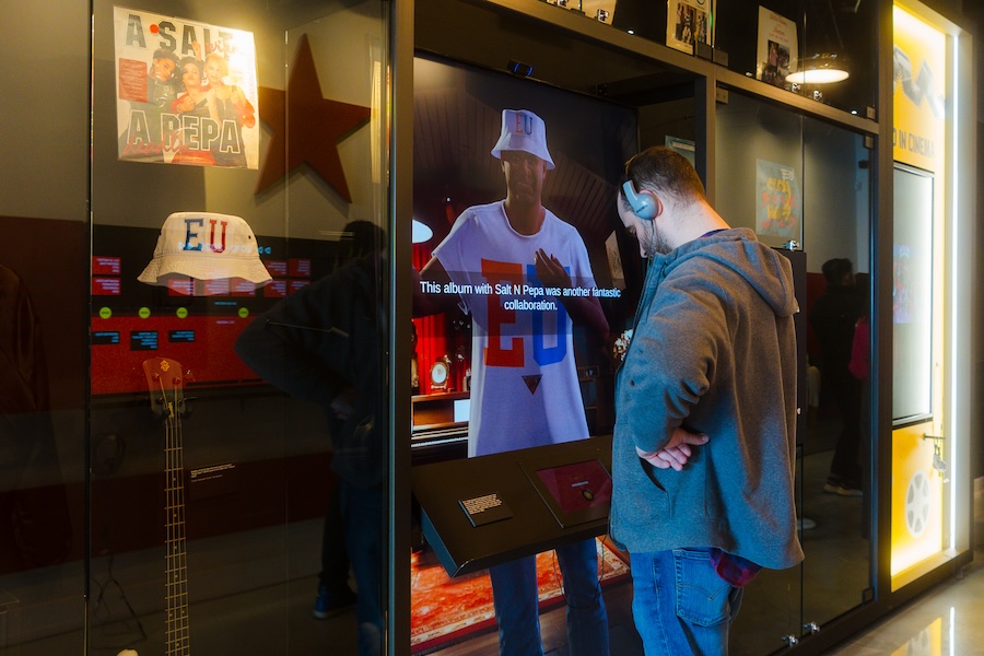 A visitor at the Go-Go Museum engages with an interactive exhibit about the band E.U. and their collaboration with Salt-N-Pepa.