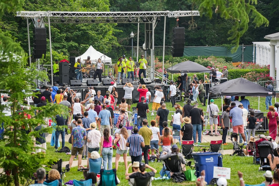 A lively crowd gathers on the lawn for an outdoor concert at the Home Rule Music Festival in Washington, DC.