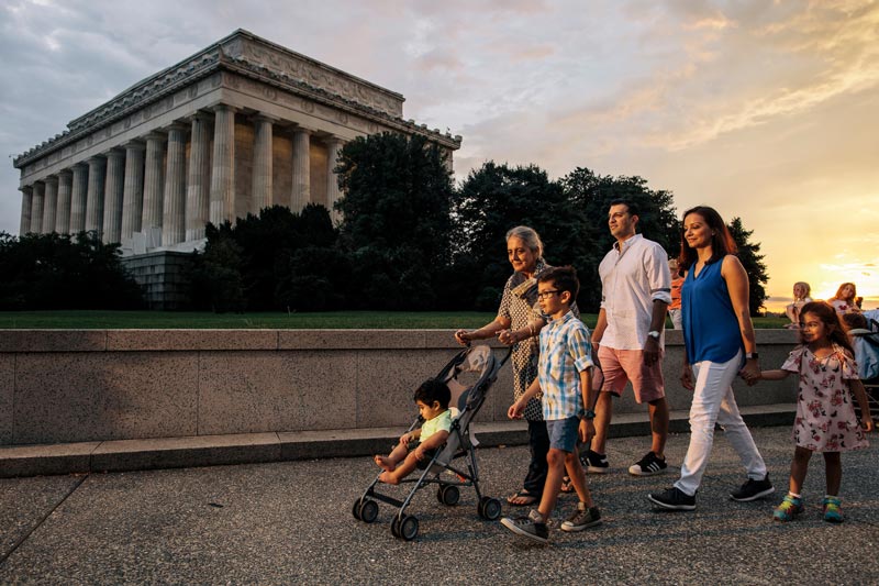Familia caminando por el National Mall en frente del Lincoln Memorial durante una noche de verano en Washington, DC