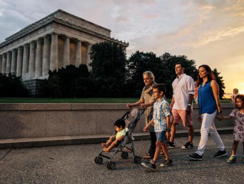 Family walking on the National Mall in front of the Lincoln Memorial during a summer evening in Washington, DC