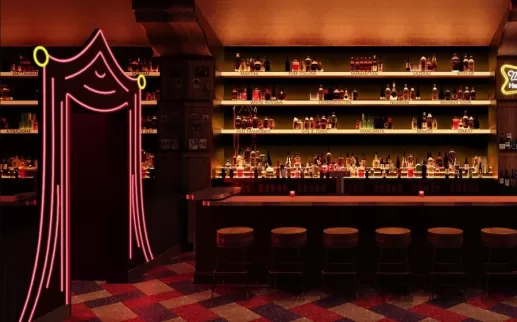 A dimly lit, retro-style bar with a backlit liquor display, a row of wooden stools and a neon pink curtain-shaped entrance on the left.
